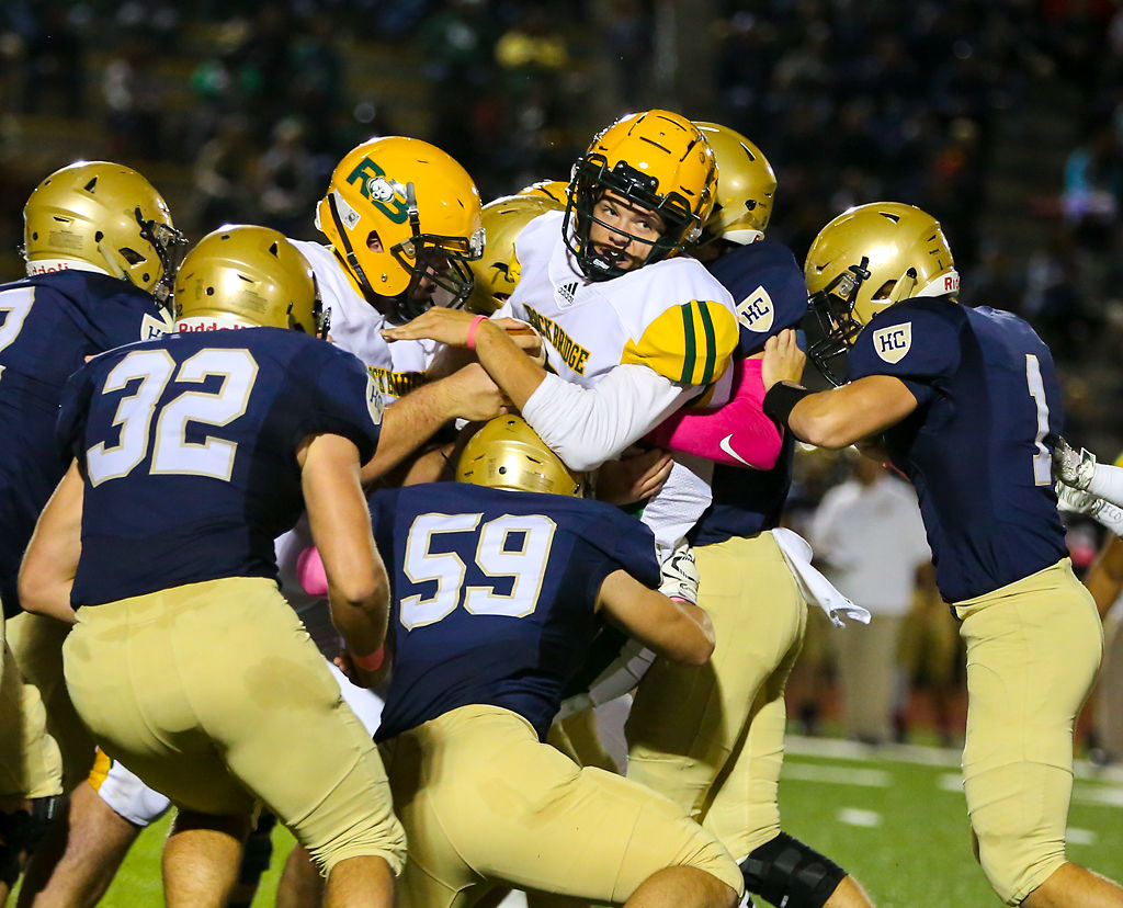 Rock Bridge quarterback Grant Hajicek is swarmed by players